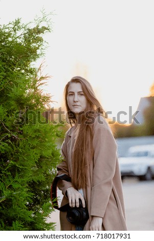 Woman photographer with camera outdoor with long hair