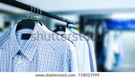 Rack of clean clothes hanging on hangers at dry-cleaning Royalty-Free Stock Photo #718021999
