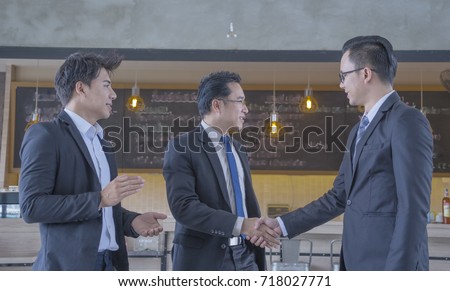 Hand shaking of businessman, business agreement success sign, group of man meeting in coffee shop shaking hands with happy smiling face. Positive result.