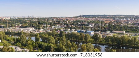 View of Praque city in Czech republic. River and forest on foreground, and red roofs on background