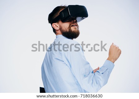 man smiling playing games in 3d virtual reality glasses on a light background                               