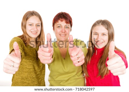 Photo of happy mother with daughters showing thumbs up