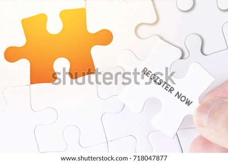 Female hand and missing puzzle with REGISTER NOW WORD