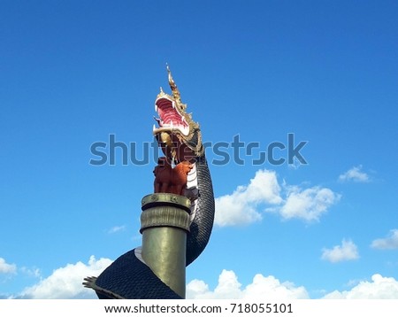 thai holy dragon - naga statue in blue sky white cloud sky protecting buddhist temple
