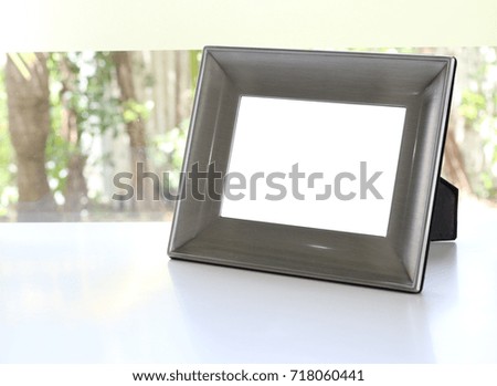 silver photo frame on the table, nature background with copy space.