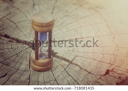 close up hourglass on old wood table with copy space background, business concept, process vintage tone