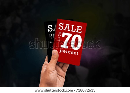 black friday concept - hand with a discount ticket isolated on crow people blur background.