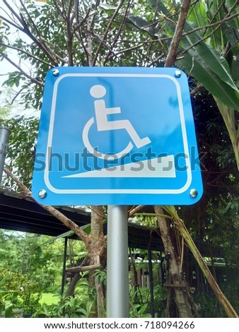 Disabled parking space and wheelchair way sign and symbols on a pole warning motorists.