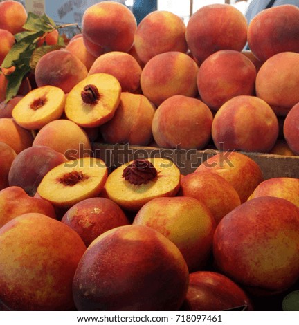 Pile of colorful peaches on an open market, fruits background. An interesting slice of peach. Contrast picture