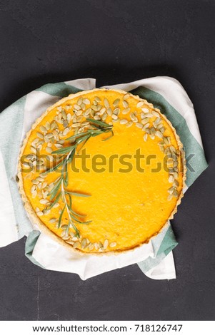 Pumpkin tart with parmesan and cream, black background, contrast, top view, vertical