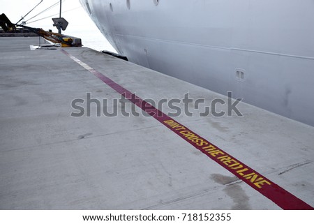 Bow of the ship and the red warning line on a asphalt