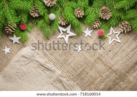 New Year and Christmas background on an old background of sackcloth. View from above. Christmas tree branches and snow, gifts and decorations