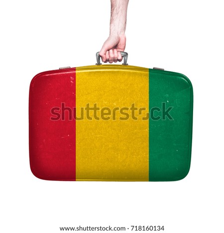 Guinea flag on a vintage leather suitcase.