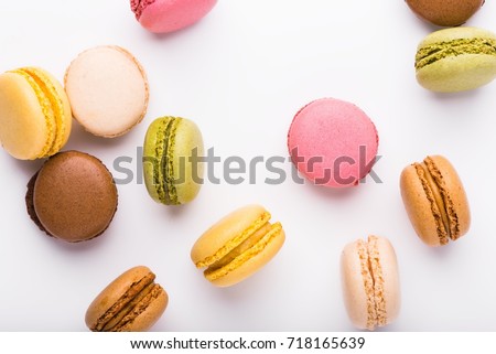 Macaron cookies scattered over white background, top view Royalty-Free Stock Photo #718165639