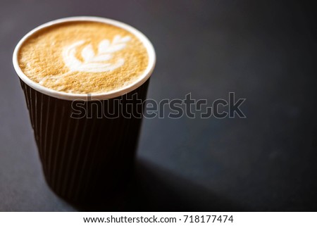 Soft focus of Latte art hot coffee in black paper cup on gray background with shadow , blurred and soft focus image Royalty-Free Stock Photo #718177474