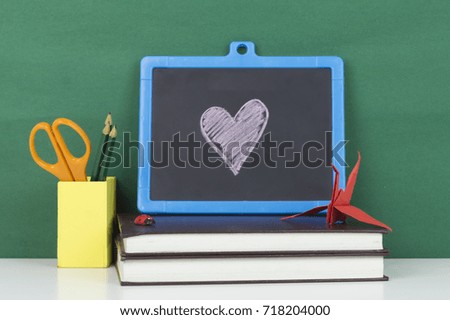  Love symbol written in white chalk on a black chalkboard. Education concept