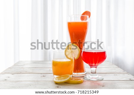 Orange juice and cocktail in white glass put on vintage wood table in the kitchen.