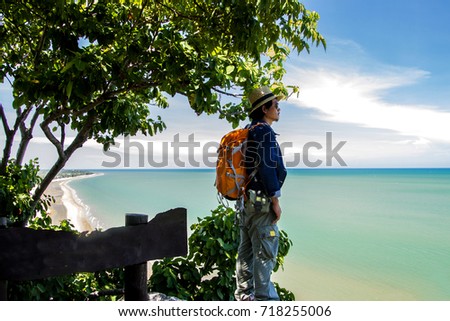 Man traveler with backpack and looking at tropical sea and beach in thailand