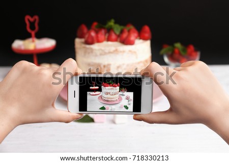 Blogger making photo of strawberry cake