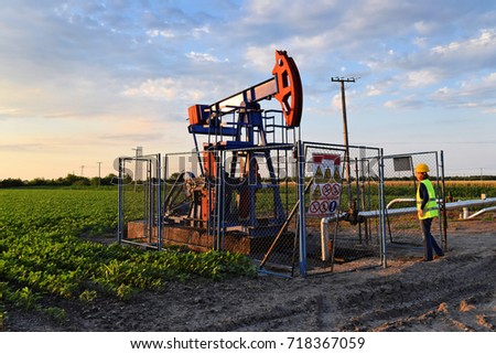 A female oil industry engineer at work on an European oil well during twilight   