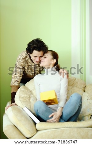 An image of couple in love, boyfriend is giving a present to his girlfriend