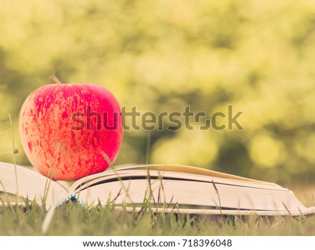 Retro and selective focus of red apple put on open book . World Book Day concept.