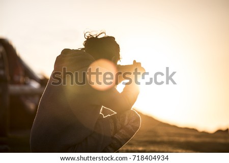 Girl photographing sunset