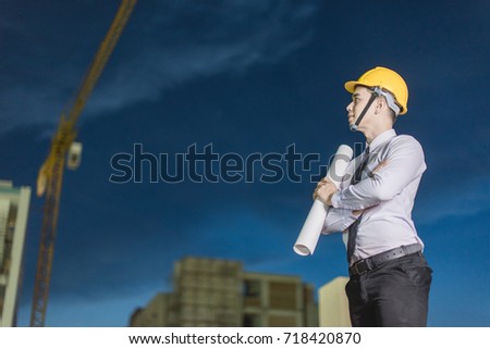 Smiling young architect or engineering builder in hard hat with tablet over group of builders at construction site, architect watching some a construction, business, building, industry, people concept