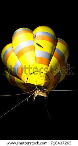 Colourful hot air ballon flying over night sky.