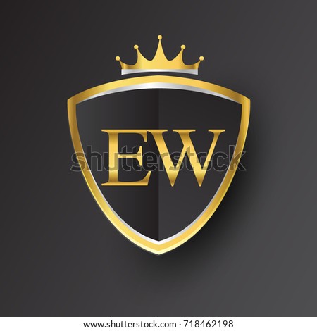 Initial logo letter EW with shield and crown Icon golden color isolated on black background, logotype design for company identity.