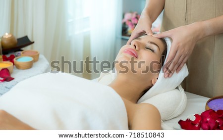 Relaxing beautiful woman having a massage for her skin on a face in beauty salon – horizontal, Beautiful young woman receiving facial massage with closed eyes at spa studio, Age 20-30 years,
