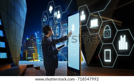 Businessman touching "Money" sign on screen of digital booth with fintech infographic icon . Hi-tech business concept .