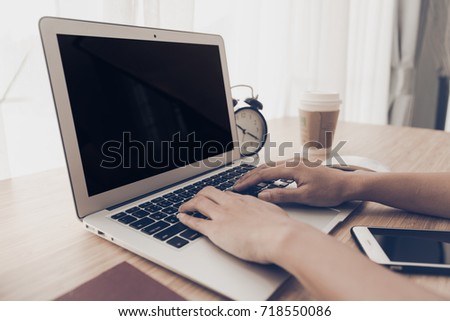 Laptop with smart phone notebook and coffee cup on workplace table.Hand typewriter on keyboard computer .