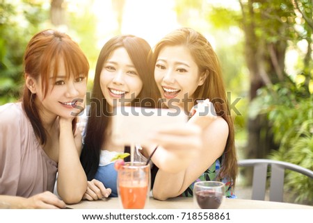 Group of friends taking selfie in garden restaurant