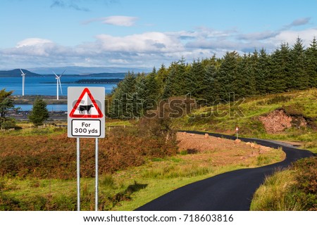 Advanced warning sign for cows over 300 yards,  A twisty farm road newly tarred & Wind turbines  on ther Clyde. Agriculture, Roads, Forestry and Renewables in one image.