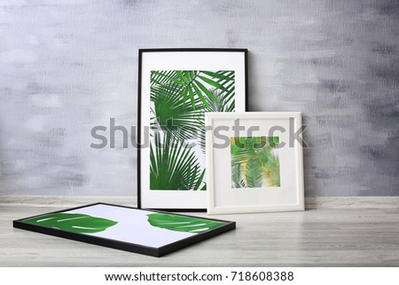 Framed pictures of tropical leaves on grey wall background