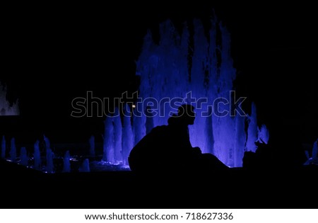 Fountain by night with the  silhouette of a couple
