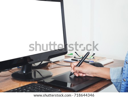 Graphic Designer using a digital tablet and pen on a computer. 
