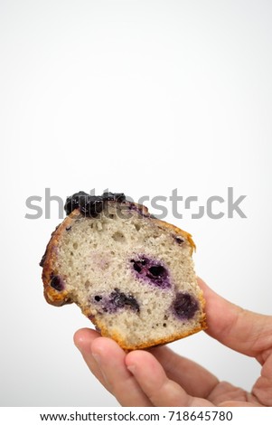 Hands holding a blueberry muffin look delicious on white background. Select focus. Vertical picture.