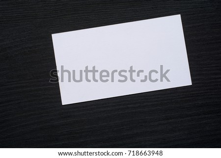 Photo of blank white business cards on a dark wooden background. Mock-up for branding identity.
