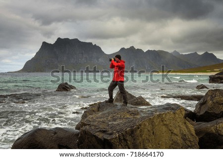 Photographer takes pictures at Uttakleiv beach on Lofoten islands in Norway