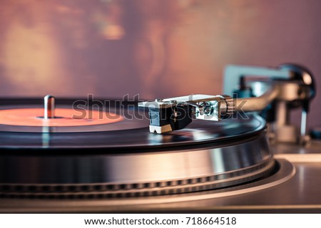 Vinyl record player, bright lights disco-bokeh. Needle on vinyl record. Royalty-Free Stock Photo #718664518