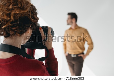 professional female photographer and handsome stylish model in photo studio   