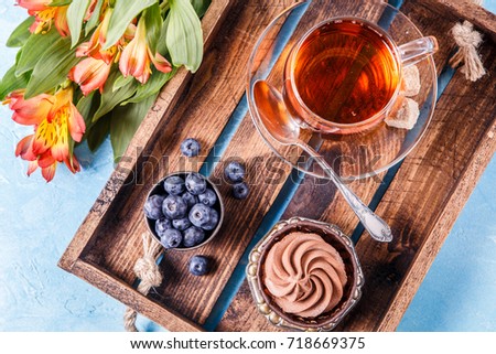 Photo of cake with blueberries, cup of tea