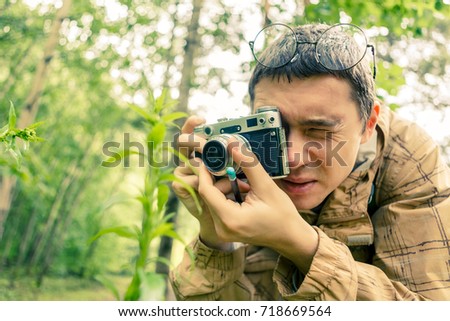 Picture of brunet with camera in woods