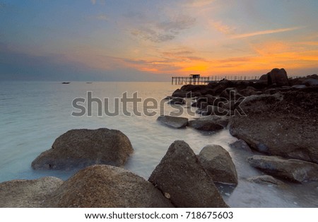 Sunrise at beach with old jetty at Batu Pahat Johor Malaysia. This image may contain noise ,blurry clouds due to long exposure, soft focus and poor lighting