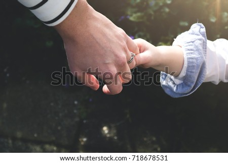 Little kid wants to show his mother something. Holding hands of his mom trying to get her to come with him. Close up.