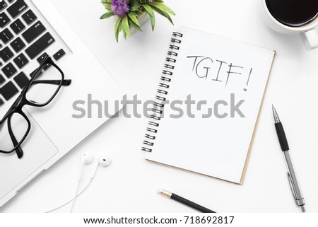 TGIF text on the notebook on white office desk table. Top view, flat lay. Royalty-Free Stock Photo #718692817