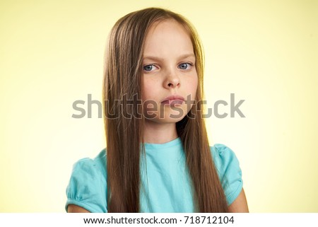 serious girl with her hair on a light background                               