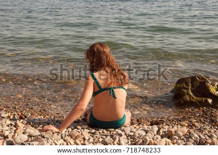 A girl in a blue bathing suit is resting on the sea. Beach in Crimea, Sevastopol